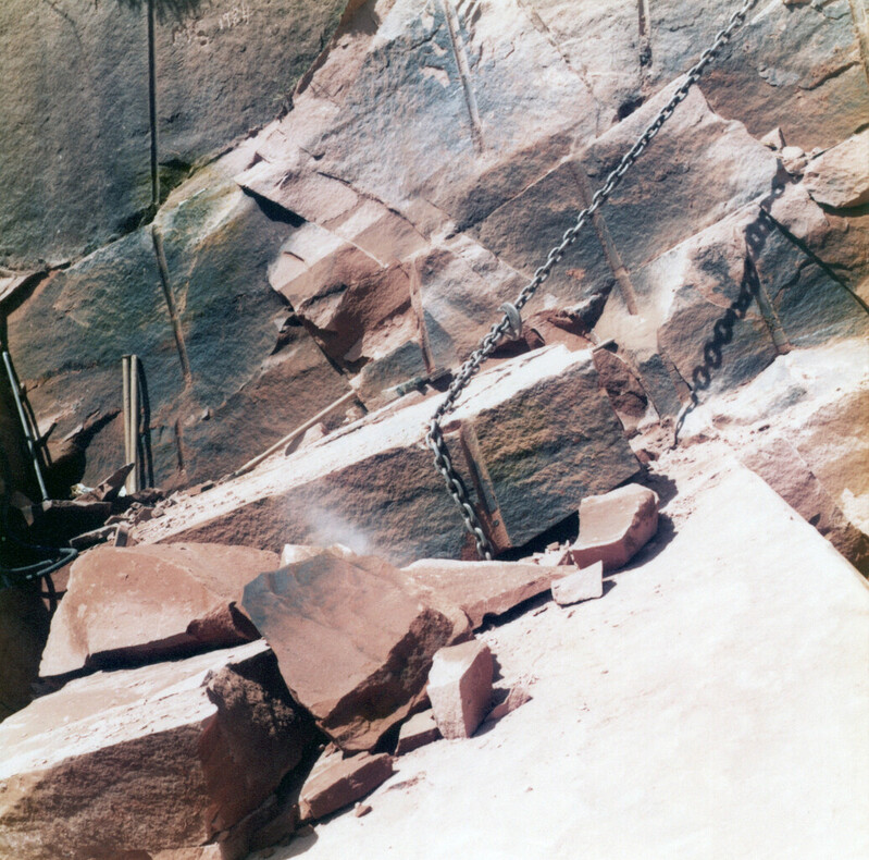 A sandstone block being dragged from the worked face using a chain and winch, in a quarry of the Locharbriggs Cluster; photographed in 1984.